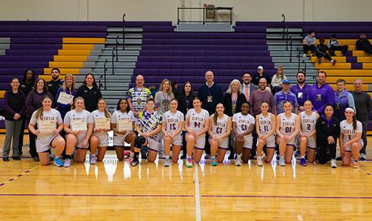 group of several basketball players and faculty and staff